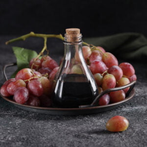 balsamic vinegar in a glass bottle and fresh grapes